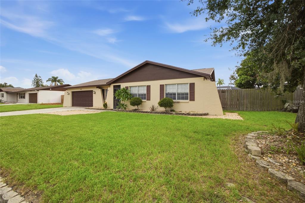 A single-story house with a tan exterior, brown roof, and a two-car garage — 2971 FOREST CIRCLE, SEFFNER, FL