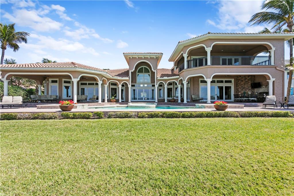 A large two-story house with a swimming pool, covered patio, and expansive green lawn — 6308 MARBELLA BOULEVARD, APOLLO BEACH, FL