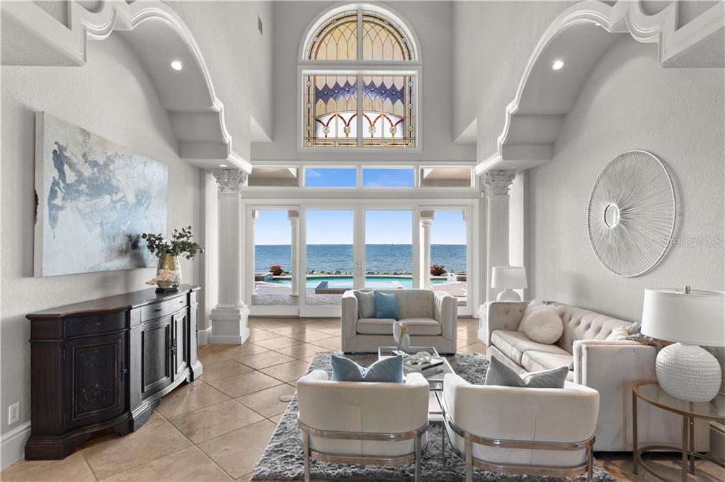 A living room with high ceilings, arched architectural details, and a view of the ocean — 6308 MARBELLA BOULEVARD, APOLLO BEACH, FL