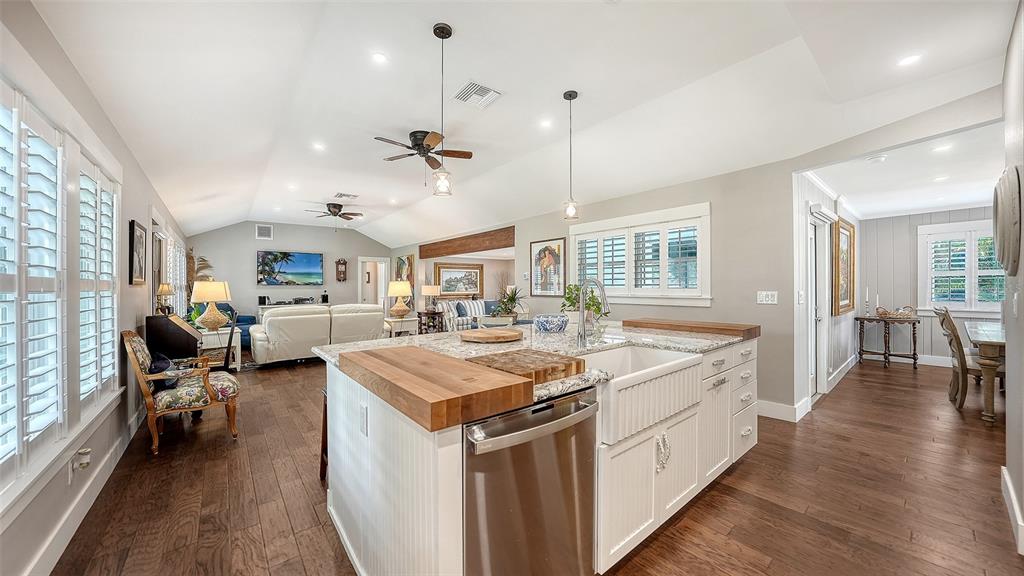 A kitchen island with a farmhouse sink and wood countertop sits in an open-concept room — 3606 PALONIA COURT, SARASOTA, FL