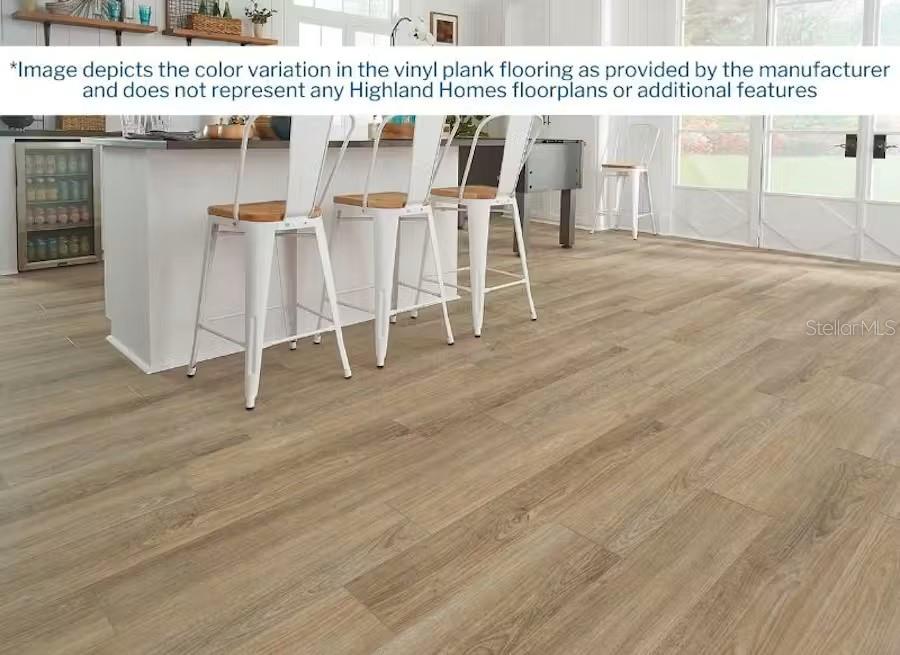 A kitchen with white bar stools and light wood-look vinyl plank flooring — 4018 WAVING HICKORY BOULEVARD, ST CLOUD, FL