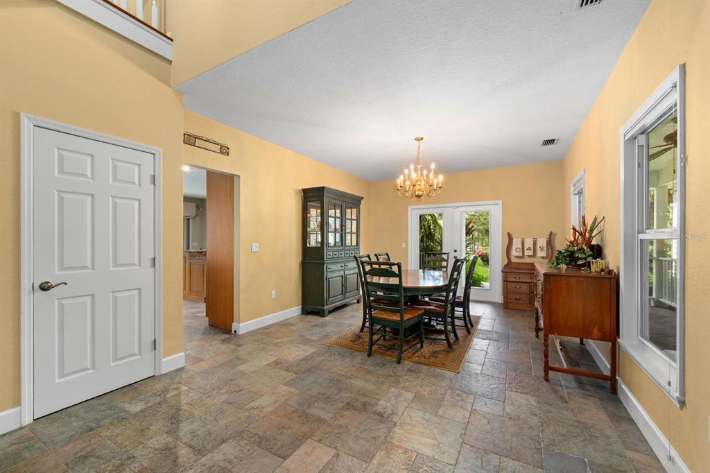 A dining room with tile floors, a dark hutch, and a table set for four — 6915 215TH STREET E, BRADENTON, FL