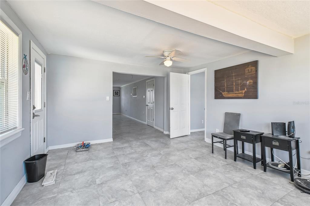 A room with light gray walls, tile flooring, a ceiling fan, and a ship wall art — 13606 ALLYN DRIVE, HUDSON, FL