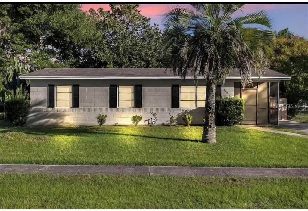 A living room features wood-look tile flooring, a ceiling fan, and a large sectional sofa — 2433 ADAMS AVENUE, DELTONA, FL