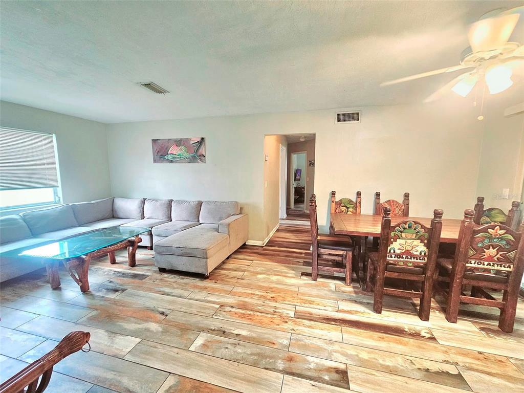 A bedroom features a bed, a wall-mounted television with string lights, and a storage cubby unit — 2433 ADAMS AVENUE, DELTONA, FL