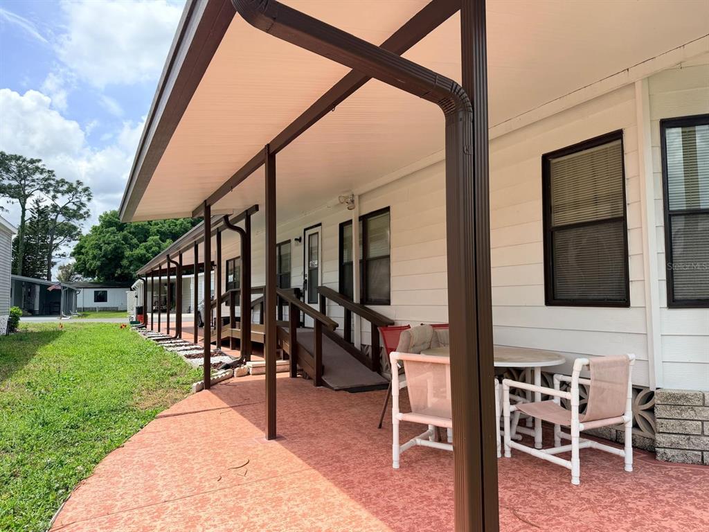 A covered patio with a ramp leads to the entrance of a mobile home — 2173 PEBBLE BEACH BOULEVARD, ORLANDO, FL