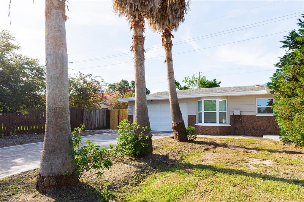A single-story house with a garage, bay window, and palm trees in the front yard — 1574 SOUVENIR DRIVE, CLEARWATER, FL