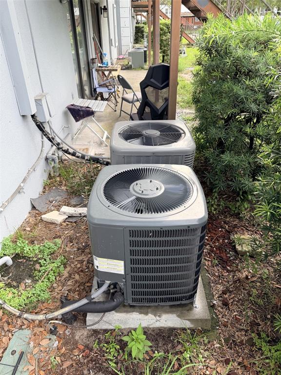 Two outdoor air conditioning units sit on concrete pads next to a building exterior — 5328 WHITEWAY DRIVE, TEMPLE TERRACE, FL