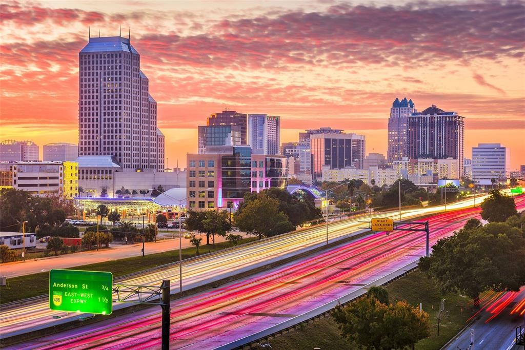 A wide-angle view of the Orlando skyline at sunset with light trails on the highway — 1008 E RIDGEWOOD ST, ORLANDO, FL