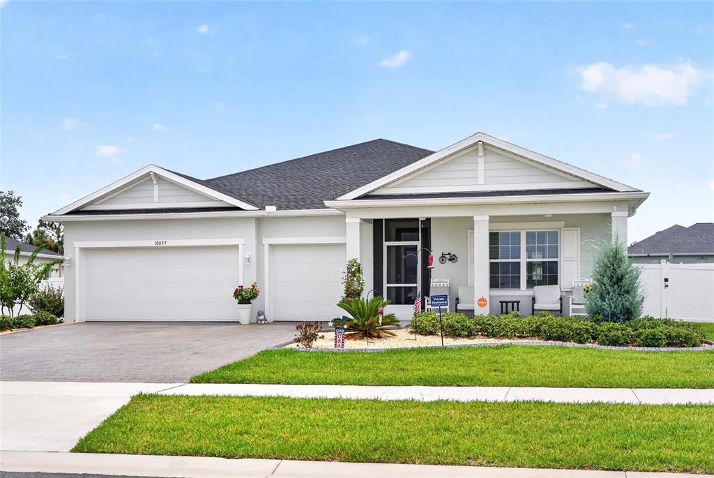 A single-story suburban house with a three-car garage and a covered front porch — 10859 SW 72ND CIRCLE, OCALA, FL