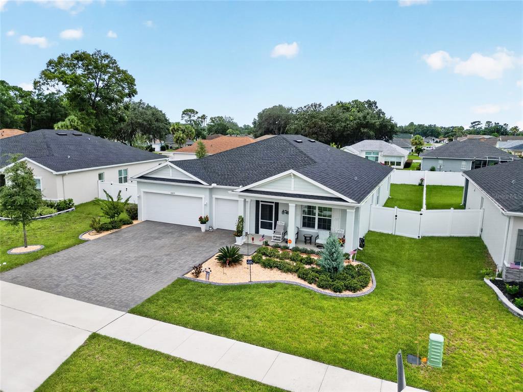 An exterior view of a single-story suburban house with a paved driveway and landscaped front yard — 10859 SW 72ND CIRCLE, OCALA, FL