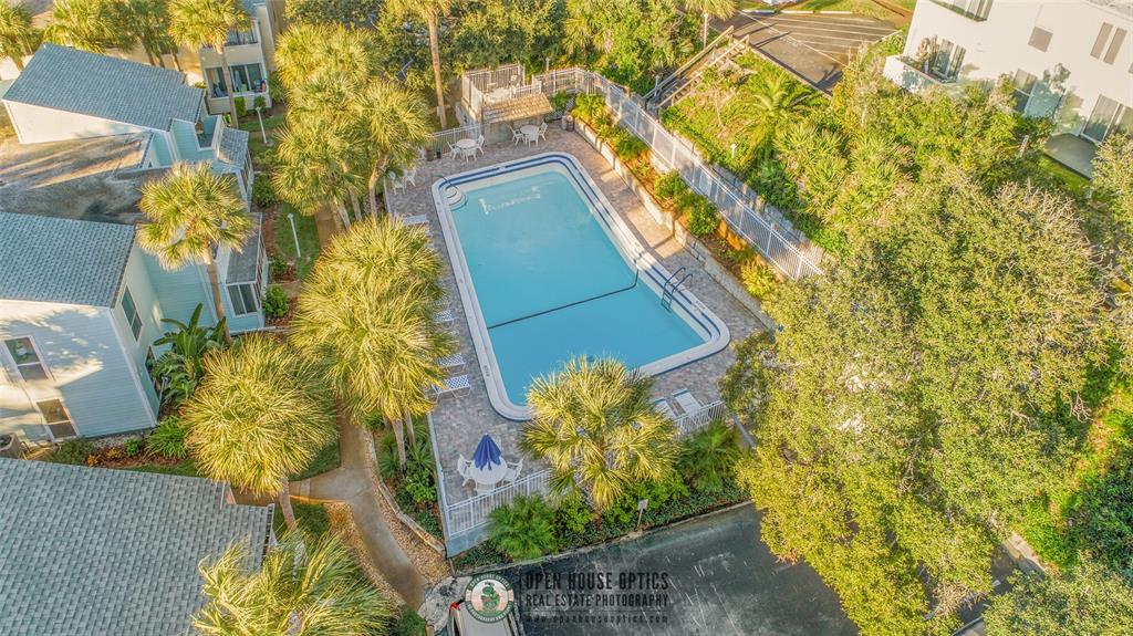An aerial view shows a rectangular swimming pool surrounded by a patio, palm trees, and buildings — 6300 A1A S UNIT A13U, ST AUGUSTINE, FL