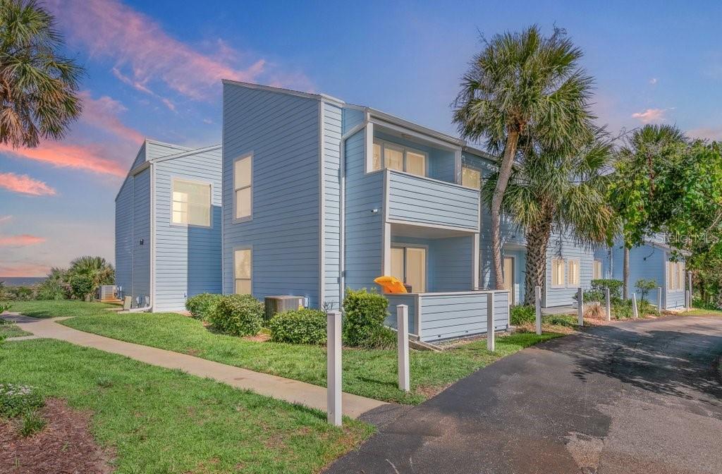 A light blue two-story building with a balcony and palm trees sits near a driveway — 6300 A1A S UNIT A13U, ST AUGUSTINE, FL