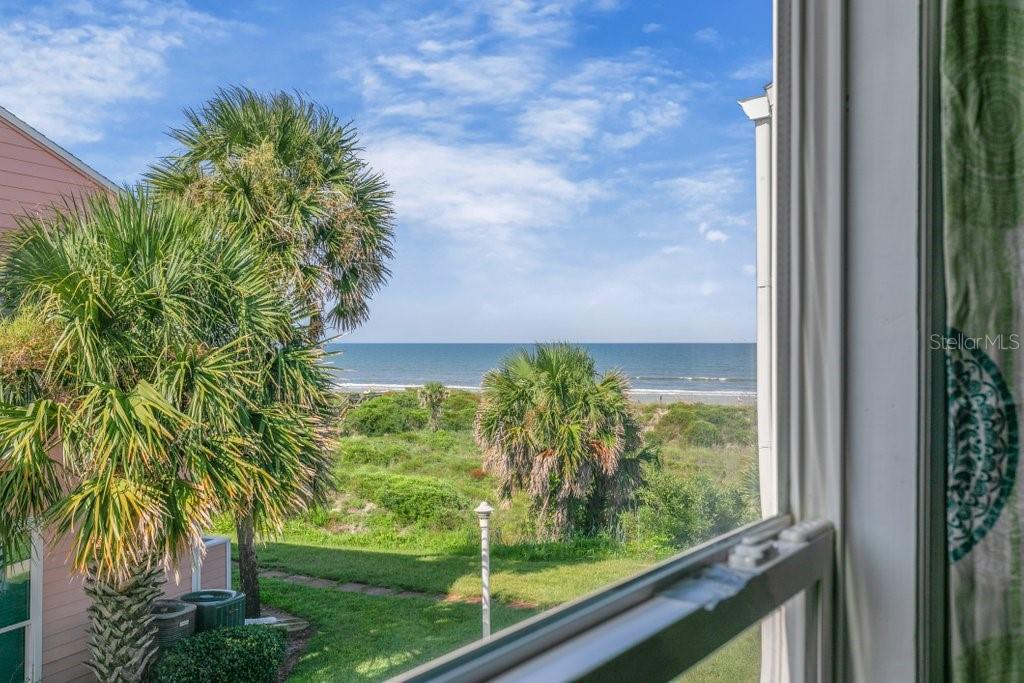 A view of the ocean and beach seen through a window from inside a room — 6300 A1A S UNIT A13U, ST AUGUSTINE, FL