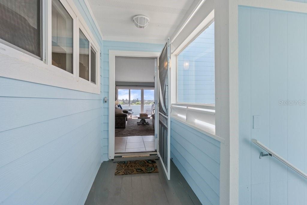 A light blue covered porch leads through an open doorway into a living room — 6300 A1A S UNIT A13U, ST AUGUSTINE, FL