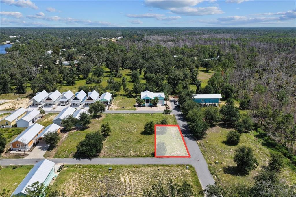 An aerial view shows a vacant rectangular lot outlined in red within a residential neighborhood — 0 SW 869TH LOOP, STEINHATCHEE, FL