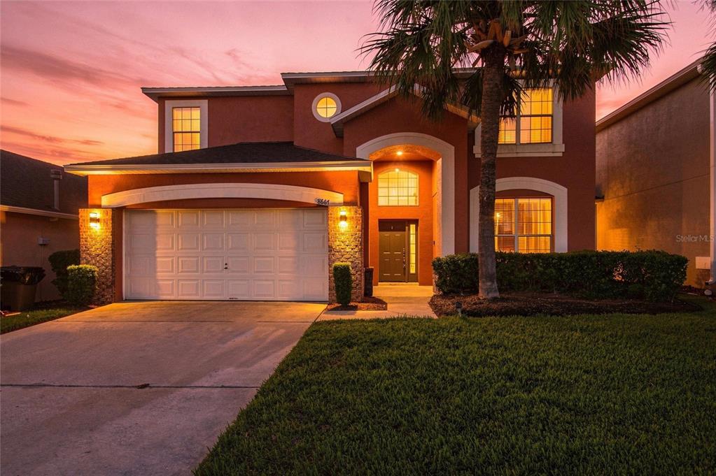 A covered patio features a dining set, ceiling fans, and artificial green wall panels — 8667 LA ISLA DRIVE, KISSIMMEE, FL