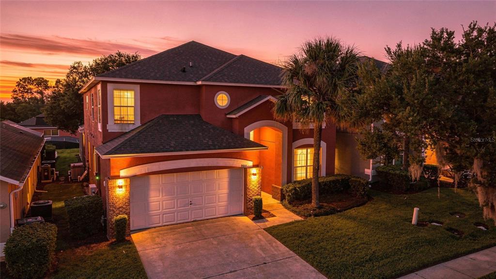 A covered patio features a concrete floor, outdoor furniture, ceiling fans, and sliding glass doors — 8667 LA ISLA DRIVE, KISSIMMEE, FL