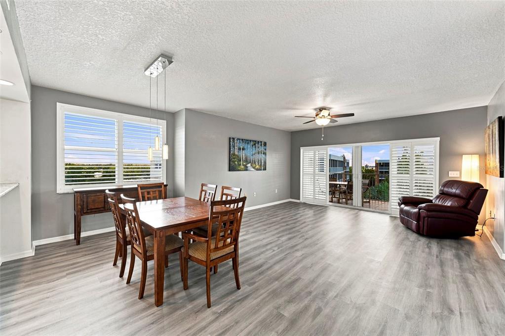 A dining area with wood furniture and a leather recliner next to a sliding glass door — 960 STARKEY ROAD UNIT 3501, LARGO, FL