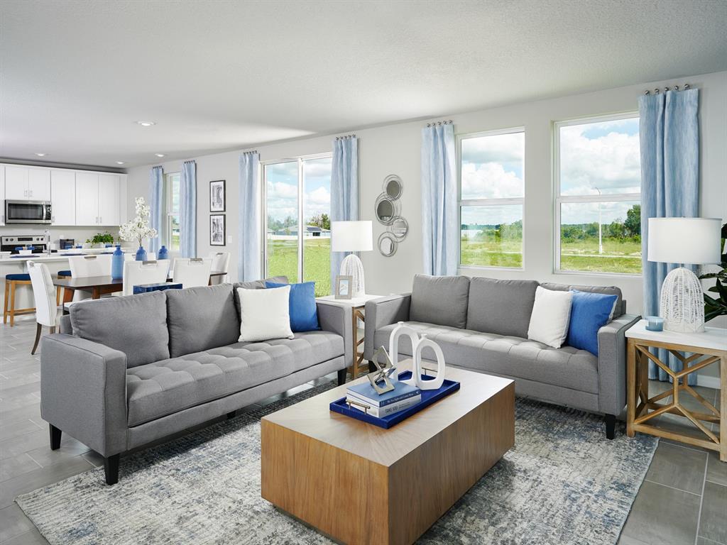 A living room with two gray sofas, a wooden coffee table, and an open kitchen — 2888 WILD OLIVE DRIVE, ST CLOUD, FL