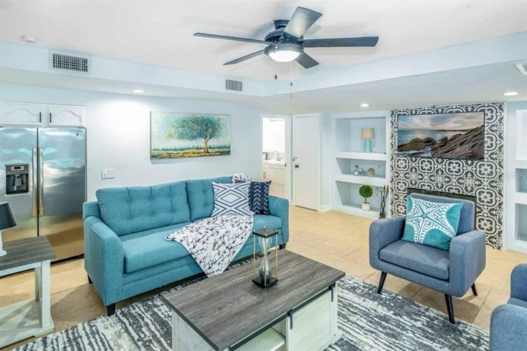 A living room features a blue sofa, an armchair, a coffee table, and a television — 2917 STETSON STREET, MELBOURNE, FL
