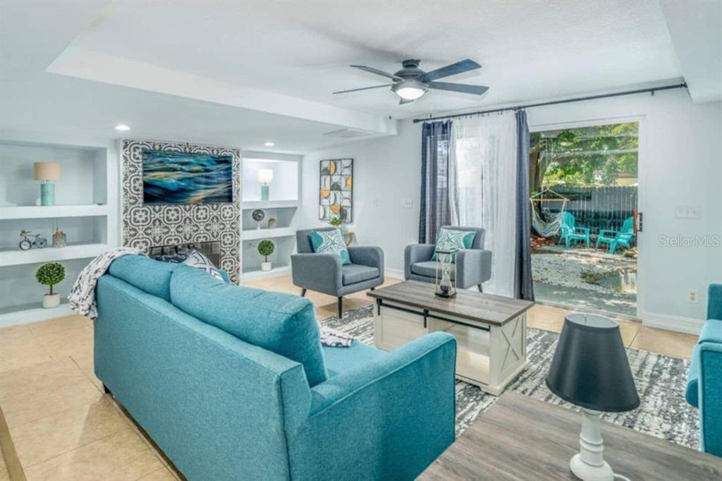 A living room features a blue sofa, two armchairs, a fireplace, and sliding glass doors — 2917 STETSON STREET, MELBOURNE, FL