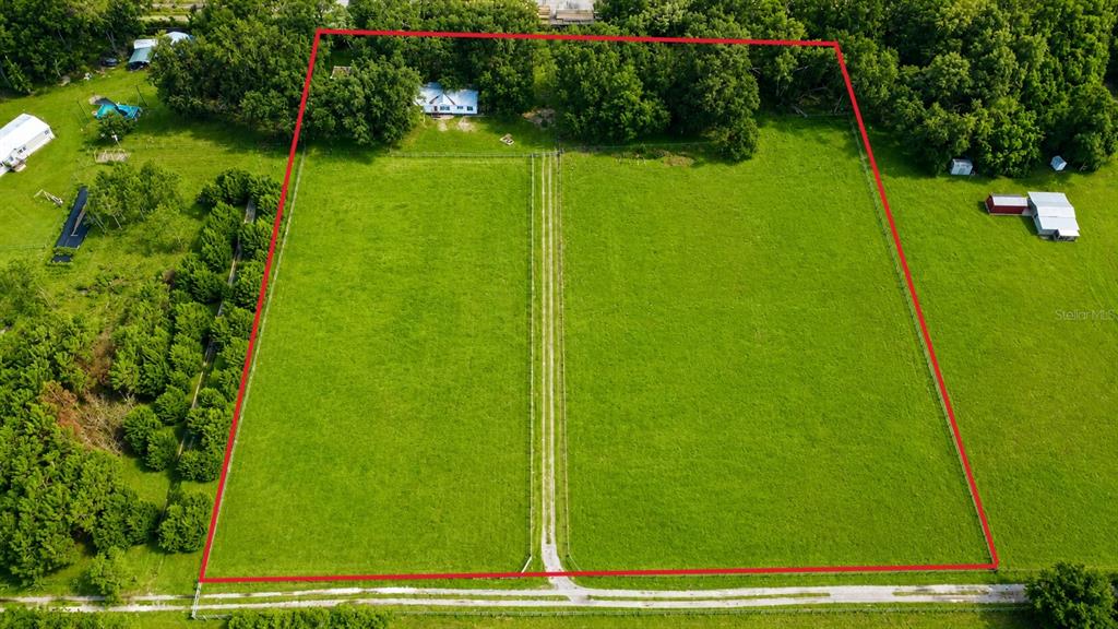 An aerial view shows a large, fenced green pasture with a house and trees — 14240 SR 471, WEBSTER, FL