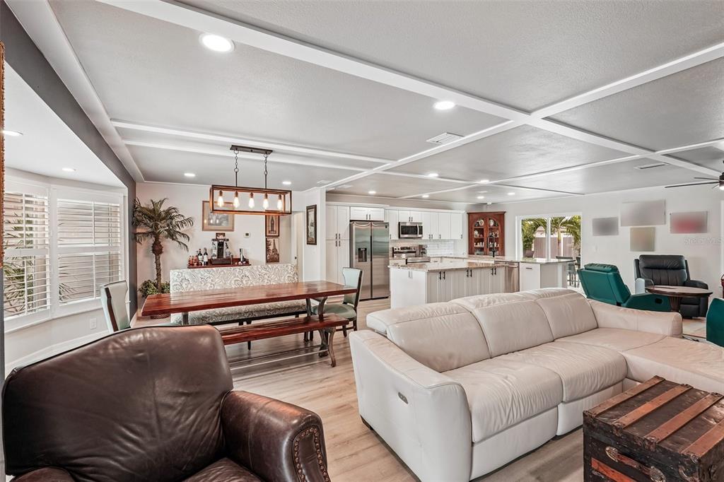 An open-concept living and dining area features white cabinetry, a coffered ceiling, and light flooring — 365 SHAMROCK BOULEVARD, VENICE, FL
