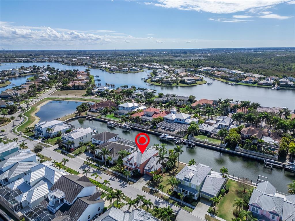 An aerial view shows a waterfront house with a red roof and a boat dock — 616 MIRABAY BOULEVARD, APOLLO BEACH, FL