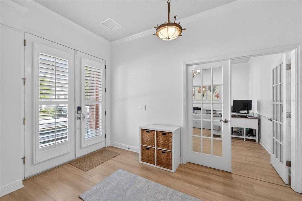 An entryway with light wood floors, a white storage unit, and French doors leading to an office — 616 MIRABAY BOULEVARD, APOLLO BEACH, FL
