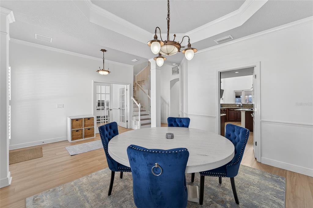 A dining area features a round white table, blue tufted chairs, and a chandelier — 616 MIRABAY BOULEVARD, APOLLO BEACH, FL
