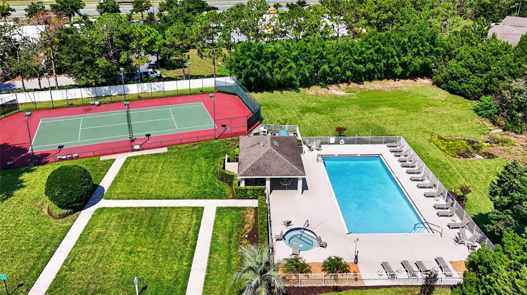 An aerial view shows a tennis court, a swimming pool, a hot tub, and landscaping — 4224 SNOWDON STREET, CLERMONT, FL