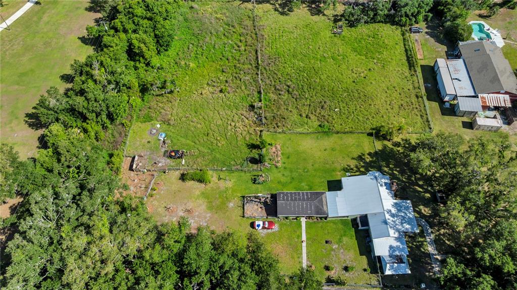 An aerial view shows a house with a metal roof, a large yard, and trees — 13610 ACKER ROAD, DOVER, FL