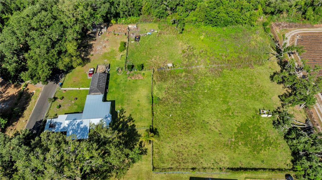 An aerial view shows a house with a metal roof on a large, grassy lot — 13610 ACKER ROAD, DOVER, FL