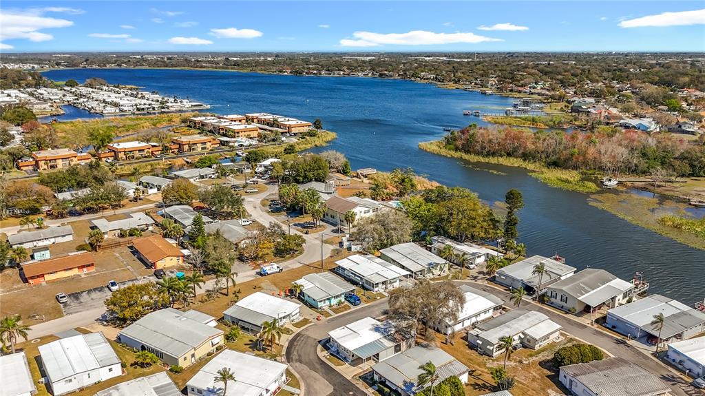 An aerial view shows a residential neighborhood of mobile homes situated along a lakefront — 10101 N LAKE DRIVE UNIT 89, LARGO, FL