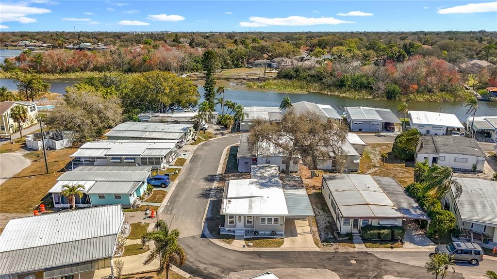 An aerial view shows a residential neighborhood of mobile homes situated along a waterfront — 10101 N LAKE DRIVE UNIT 89, LARGO, FL