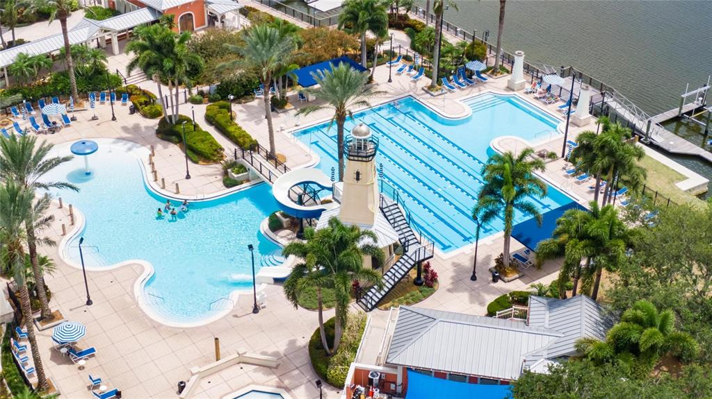 An aerial view of a resort-style swimming pool complex featuring a lighthouse-themed water slide — 508 WINTERSIDE DRIVE, APOLLO BEACH, FL