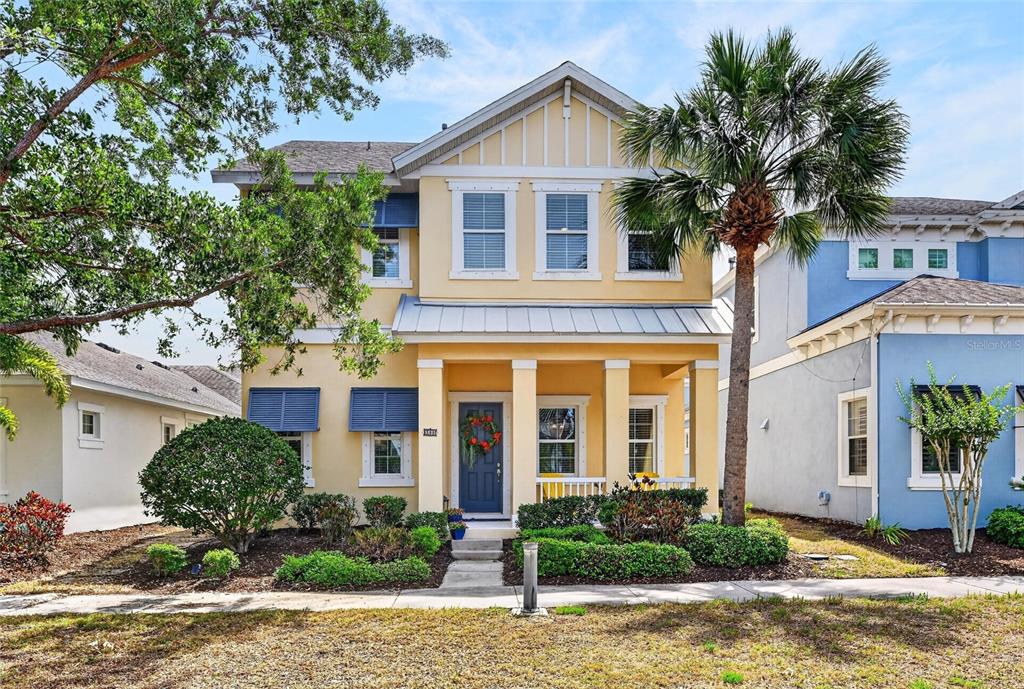 A two-story yellow house with a front porch, blue shutters, and a palm tree — 508 WINTERSIDE DRIVE, APOLLO BEACH, FL