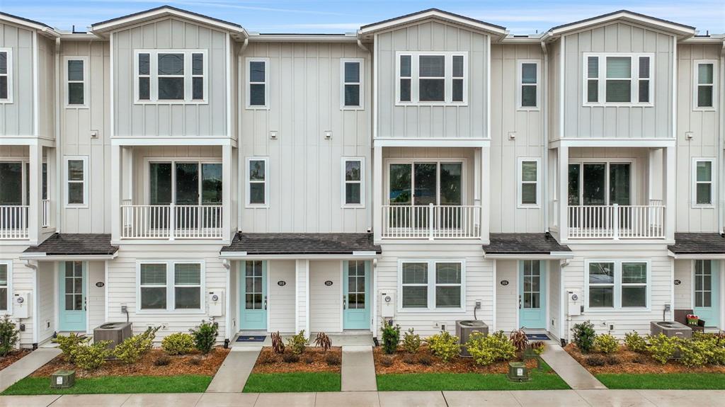 A row of modern three-story townhomes features light-colored siding, balconies, and light blue front doors — 6 BEACH WAY, JACKSONVILLE BEACH, FL