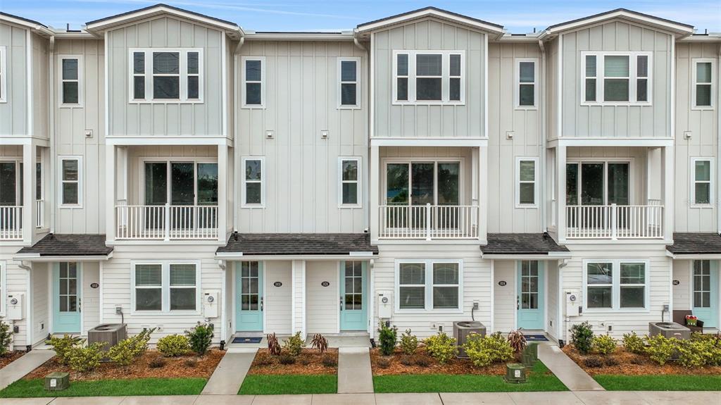 A row of three-story townhomes features light-colored vertical siding, balconies, and light blue front doors — 6 BEACH WAY, JACKSONVILLE BEACH, FL