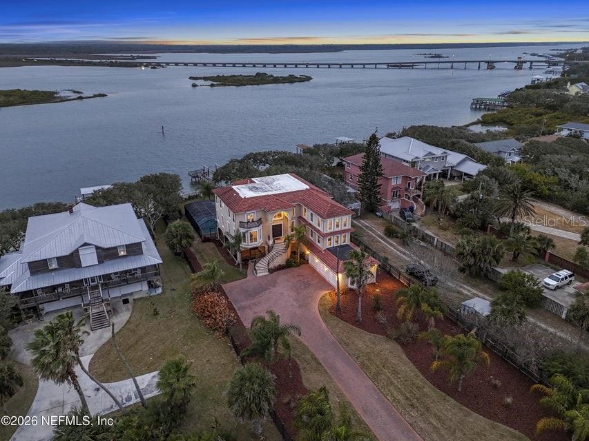 An aerial view shows a multi-story waterfront home with a red tile roof and driveway — 7149 MIDDLETON AVENUE, ST AUGUSTINE, FL