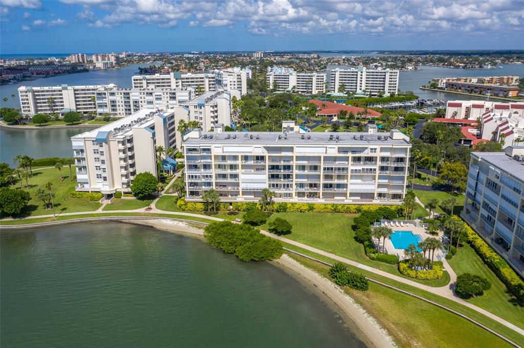 An aerial view of waterfront apartment buildings with a swimming pool and green lawn — 7882 SAILBOAT KEY BOULEVARD S UNIT 405, SOUTH PASADENA, FL