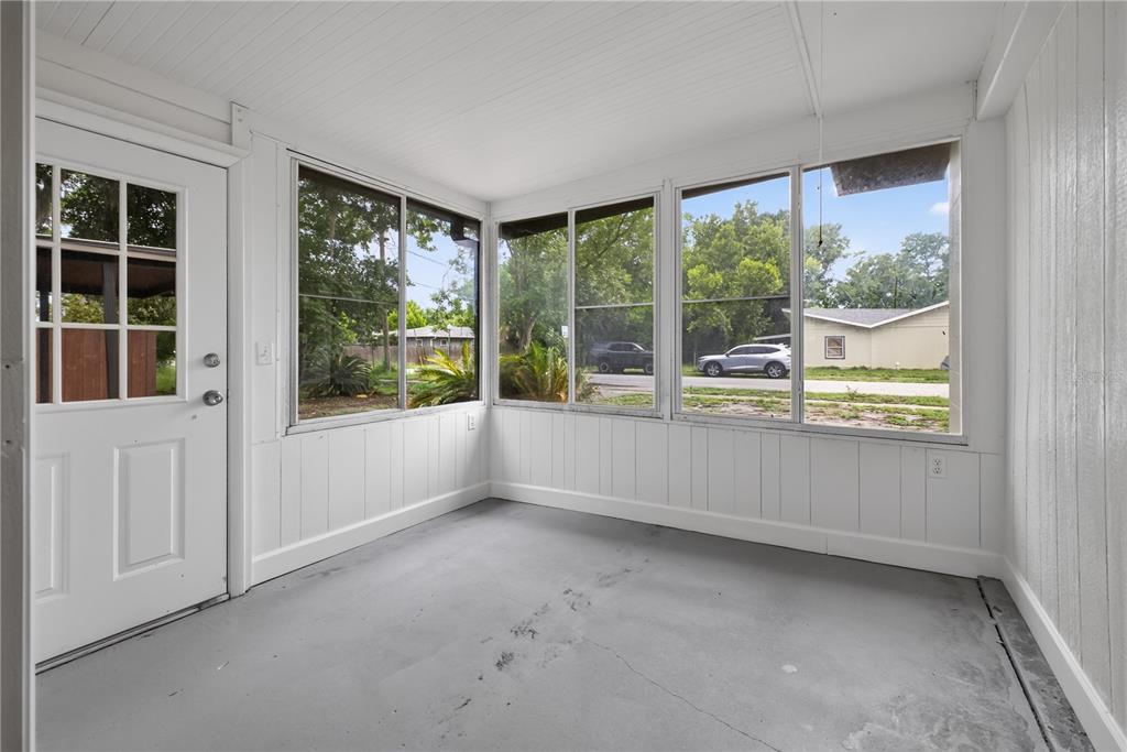 A covered front porch with black columns, white walls, and black shutters on the windows — 2390 NORTHLAND ROAD, MOUNT DORA, FL