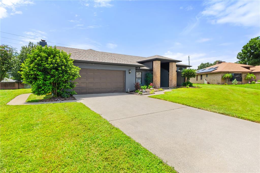 A single-story house with a gray exterior, brown garage door, and a concrete driveway — 280 SANTA ROSA DRIVE, WINTER HAVEN, FL