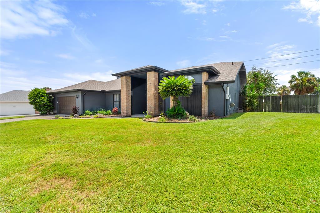 A single-story house with a dark gray exterior, brick pillars, and a large front lawn — 280 SANTA ROSA DRIVE, WINTER HAVEN, FL