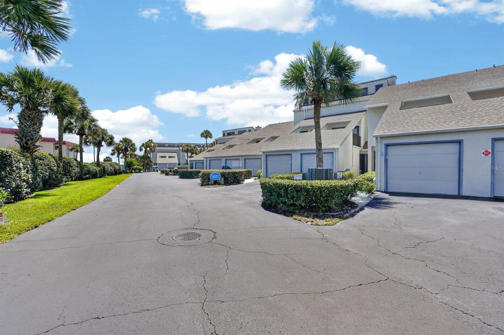 A paved driveway leads to a row of townhouses with garages and palm trees — 890 A1A BEACH BLVD #28 UNIT 28, ST AUGUSTINE, FL