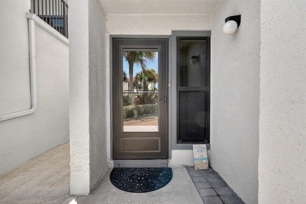 A front entryway features a storm door, a side window, and a welcome mat — 890 A1A BEACH BLVD #28 UNIT 28, ST AUGUSTINE, FL