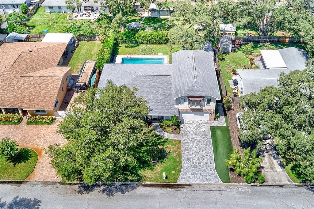An aerial view shows a house with a gray roof, a pool, and a paved driveway — 812 WILLOWBRANCH AVENUE, CLEARWATER, FL