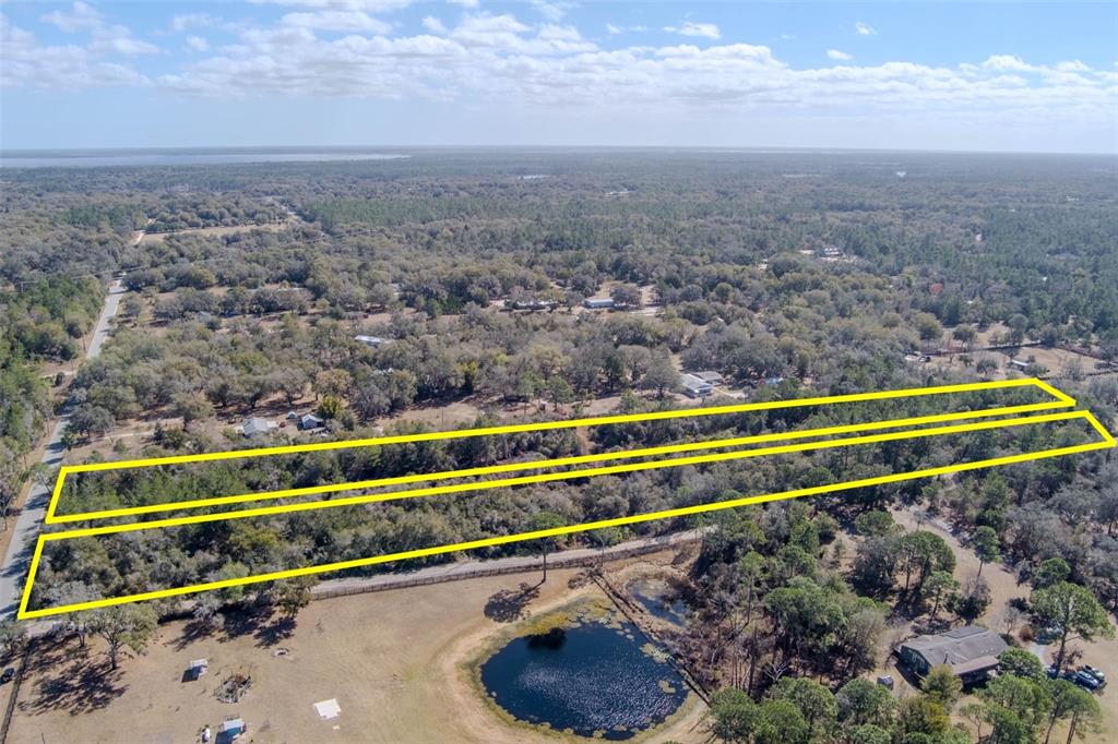 An aerial view shows a rectangular plot of land outlined in yellow near a pond — COCHRAN ROAD, GENEVA, FL