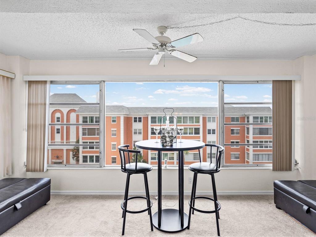 A living room and dining area with carpeted floors, a ceiling fan, and neutral walls — 6800 20TH AVENUE N UNIT 503, ST PETERSBURG, FL
